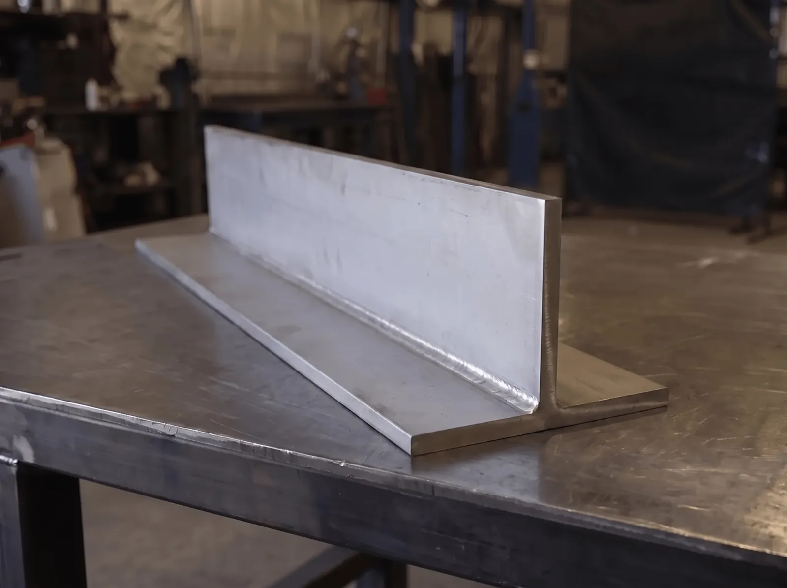 Stainless WT / Structural T section on a steel work table: one flange plate with a vertical web welded to it, 316 mill finish
